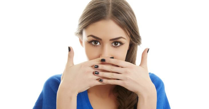 Teenage girl covering her mouth with hands.