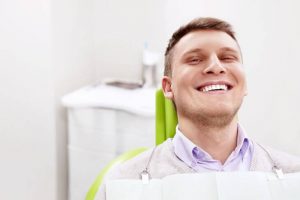 Satisfied man in a dental chair after cavity filling treatment.