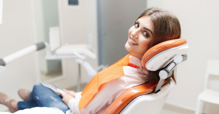 A young woman with beautiful smile in a dental chair.