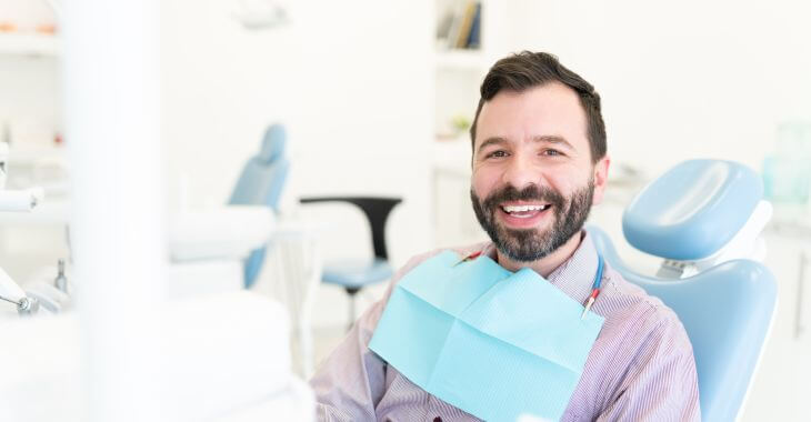 A relaxed satisfied man in a dental chair after root canal procedure.