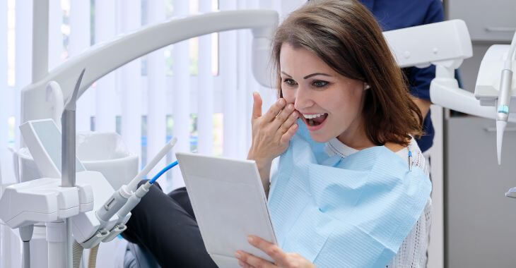 A satisfied woman in a dental chair after dental implants procedure.