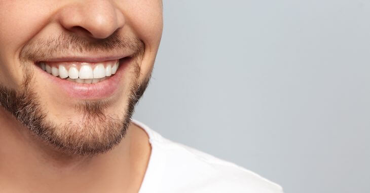 A man showing his perfect teeth after dental implant treatment in his smile.