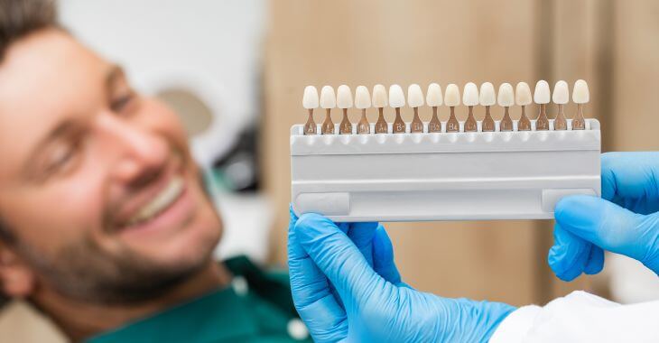 A man in a dental chair before a veneer replacement.