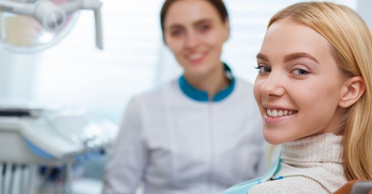 A satisfied woman in a dental chair after cavities treatment.