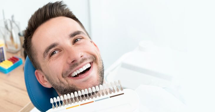 Satisfied man in a dental chair after teeth bleaching procedure.