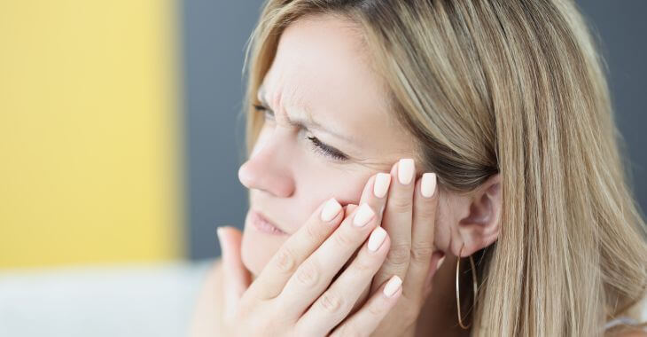 Woman suffering from pain caused by wisdom tooth.