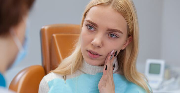 Concerned young woman discussing her dental problem with a dentist.