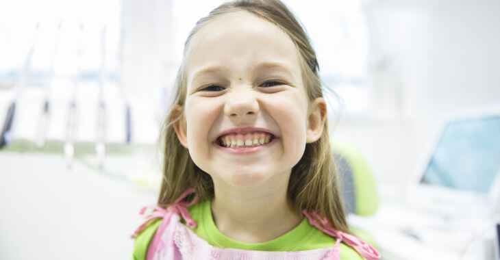 Smiling little girl showing her teeth.