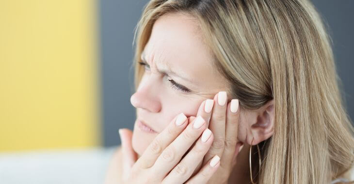 Woman suffering from jaw pain.