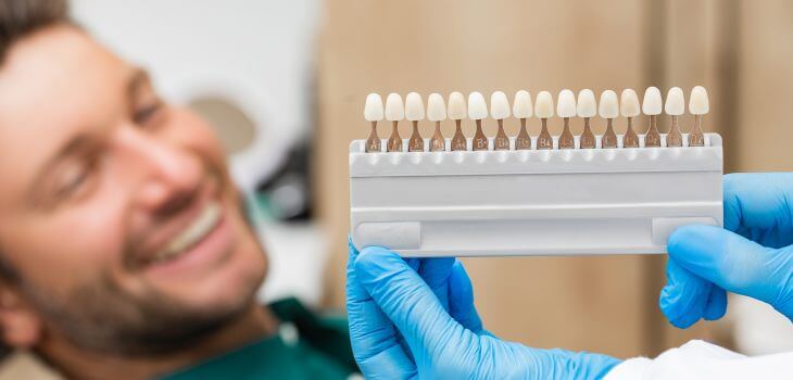 Happy man in a dental chair during cosmetic dental veneers consultation.