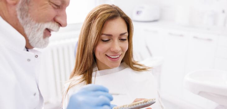 A dentist and a woman patient discussing cosmetic veneers.