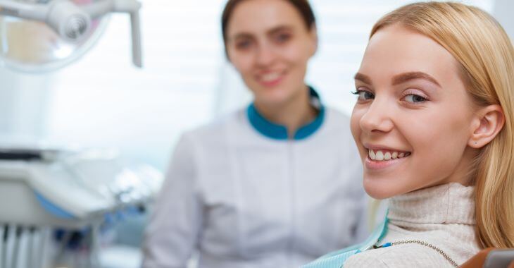 A dentist and a  satisfied young woman after dental treatment.