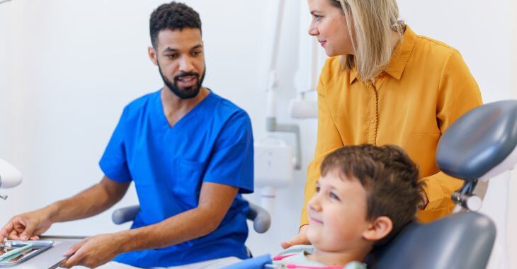 A mother assisting her little son during a dental appointment.