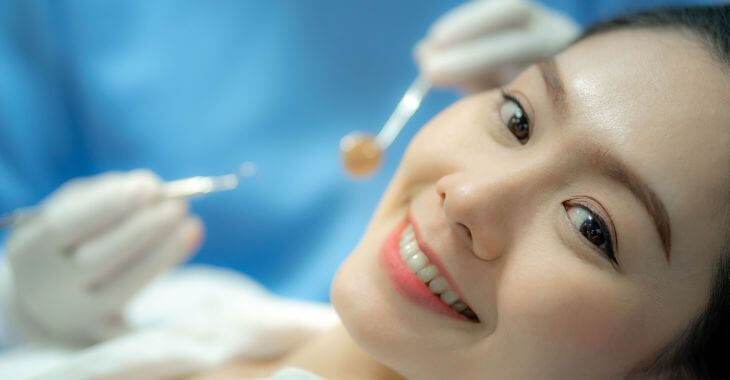 Asian woman undergoing dental checkup.