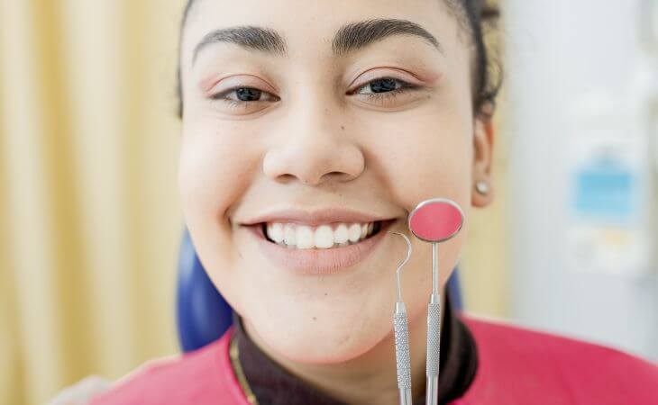 A happy dental patient woman after a dental checkup showing her nice teeth in a smile.