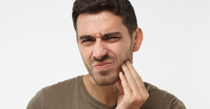 Man feeling tooth pain after filling procedure.