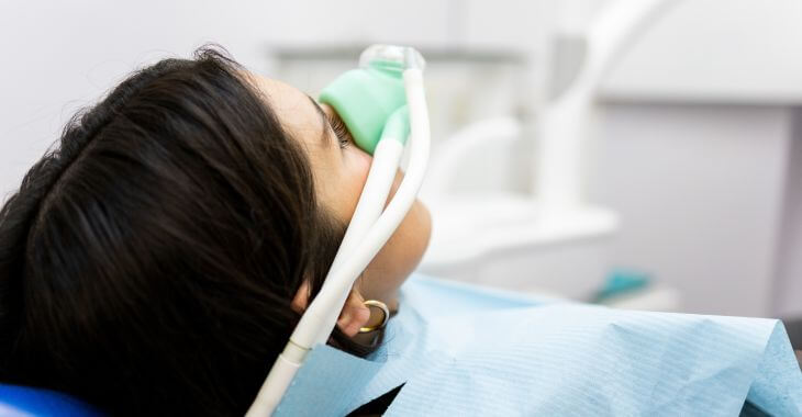 A woman in a dental wearing a mask when getting sedated with nitrous oxcide before the procedure